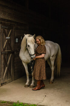 Lipizzan mare expressing affection by touching the hand of a woman.